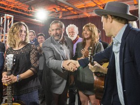 NDP Leader Tom Mulcair greets Canadian musicians Sarah Harmer, left, Luke Doucet, right, and Melissa McClelland, second right, from the duo Whitehorse, Monday, October 5, 2015 in Toronto.