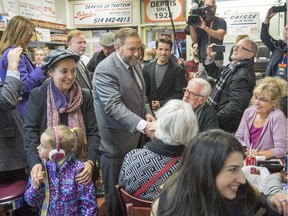 NDP leader Tom Mulcair greets patrons as he arrives for lunch at Schwartz's delicatessenFriday, October 9, 2015 in Montreal.