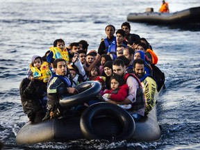 Migrants and refugees arrive on a dinghy on the Greek island of Lesbos, after crossing the Aegean sea from Turkey, on October 14, 2015. More than 400,000 refugees, mostly Syrians and Afghans, arrived in Greece since early January while dozens were drowned trying to make the crossing. In total 710,000 have entered the EU through Greece and Italy during the same period, according to the European Agency Frontex border surveillance. The migration issue has caused deep divisions within the European Union, which is trying to set the distribution of migrants among its member countries or limit the flow.