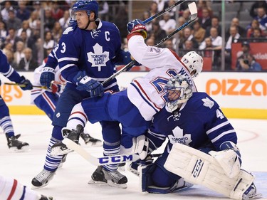 Toronto Maple Leafs' Dion Phaneuf (3) defends as Montreal Canadiens' Dale Weise (22) falls into Maple Leafs goalie James Reimer during third period NHL action in Toronto on Wednesday, Oct. 7, 2015.