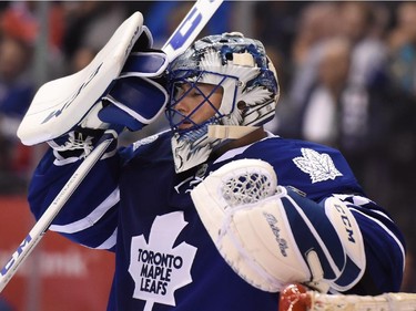 Toronto Maple Leafs goalie Jonathan Bernier adjusts his mask after Montreal Canadiens' Alex Galchenyuk, not shown, scored during third period NHL action in Toronto on Wednesday, Oct. 7, 2015.