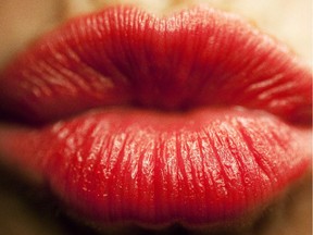 Kiss and makeup: Lips covered with red lipstick.