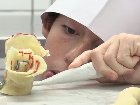 Young cooking student puts the final touches on a pastry during a class offered by Ritz-Carlton executive chef Johnny Porte on Sunday.
