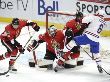 Ottawa Senators' Cody Ceci (5) clears the puck from goalie Matt O'Connor (29) as Chris Wideman (45) battles with Montreal Canadiens' Zack Kassian (8) during the first period of a pre-season NHL hockey game, Saturday October 3, 2015, in Ottawa.
