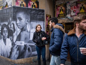 An international collective of street photographers papered news photographs from around the world on walls of different districts Montreal. Above, an image from Paris.