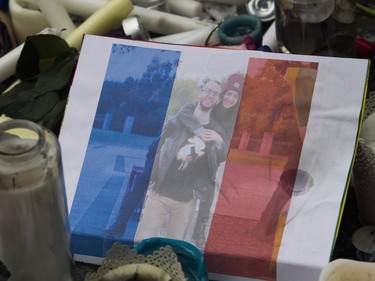 A photo superimposed on a French flag sits within a makeshift memorial outside the French consulate in Montreal on Sunday, Nov. 15 , 2015. after a March in solidarity with Paris.