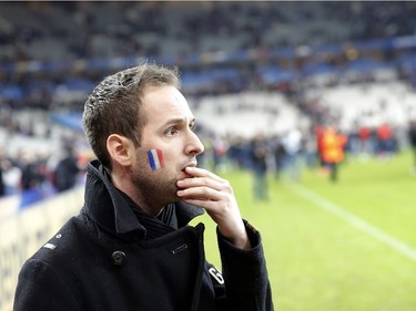 A French supporter reacts after invading the pitch of the Stade de France stadium at the end of the international friendly soccer match between France and Germany in Saint Denis, outside Paris, Friday, Nov. 13, 2015. Hundreds of people spilled onto the field of the Stade de France stadium after explosions were heard nearby. French President Francois Hollande says he is closing the country's borders and declaring a state of emergency after several dozen people were killed in a series of terrorist attacks.