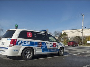 A Montreal police cruiser is shown parked outside a secondary school in the Montreal borough of Dorval, Tuesday, November 3, 2015. A number of bomb threats have been made against schools across the province.
