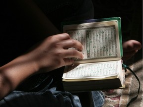 A Palestinian boy reads verses from the Koran during a class on how to read Islam's holy book, at a camp in a local mosque in Gaza City on June 11, 2012.
