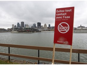A sign warns to avoid contact with the water along the shore of the St. Lawrence River Friday, Nov. 13, 2015, in Montreal. The city is in the process of dumping 8 billion litres of raw sewage into the river while repairs are being made to the sewage collectors.