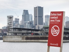 A sign warns to avoid contact with the water along the shores of the St. Lawrence River, Wednesday, November 11, 2015 in Montreal.