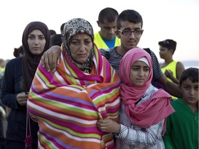 A Syrian family walks after they arrived with other refugees from Turkey to the shores of the Greek island of Lesbos, on a inflatable dinghy, Friday, Sept. 25, 2015.