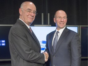 Alain Bellemare, president and Chief Executive Officer Bombardier Inc., right, and Quebec Economy Minister Jacques Daoust shake hands after a news conference Thursday, October 29, 2015 in Montreal. The Quebec government is investing $1 billion in Bombardier's CSeries aircraft program.