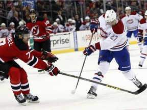 Montreal Canadiens centre Alex Galchenyuk (27) tries to shoot against New Jersey Devils defenceman Jon Merrill (7) during the first period of an NHL hockey game, Friday, Nov. 27, 2015, in Newark, N.J.