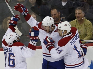 Montreal Canadiens centre Alex Galchenyuk, centre, celebrates with teammates P.K. Subban, left, and Tomas Plekanec, of the Czech Republic, after scoring a goal against the New Jersey Devils during the third period of an NHL hockey game, Friday, Nov. 27, 2015, in Newark, N.J.