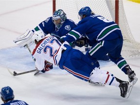 Montreal Canadiens' Alex Galchenyuk (27) dives and takes a shot but is stopped by Vancouver Canucks' goalie Ryan Miller as Chris Tanev (8), right, defends during the first period of an NHL hockey game in Vancouver, B.C., on Tuesday, Oct. 27, 2015.