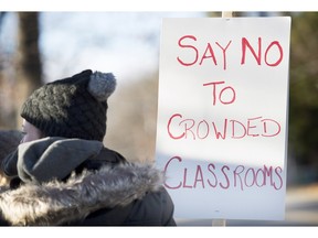 School teachers demonstrate outside a high school near Montreal, Monday, November 16, 2015, where they protested against the ongoing austerity cuts by the Quebec government.