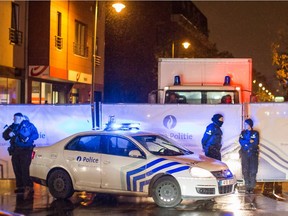 Belgian police guard a street in Brussels on Saturday, Nov. 14, 2015, where arrests were made linked to the attacks in Paris. Belgium's federal prosecutor's office spokesman Jean-Pascal Thoreau says the arrests came after a car with Belgian license plates was seen close to the Bataclan theater in Paris on Friday night, one of the places where victims were killed.