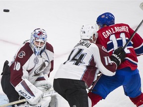 Montreal Canadiens' Brendan Gallagher (11) moves in on Colorado Avalanche goaltender Reto Berra as the Avalanche's Blake Comeau (14) defends during third period NHL hockey action in Montreal, Saturday, November 14, 2015.