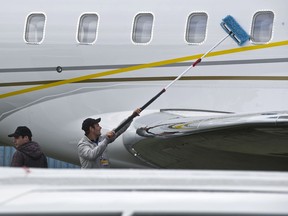 An employee cleans the fuselage of a Bombardier's Global 6000 aircraft, during the Latin American business aviation fair being held in Sao Paulo, Brazil, on August 15, 2013.
