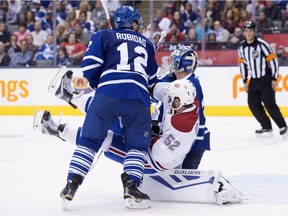 The Canadiens' Bud Holloway is tripped by Maple Leafs defenceman Stéphane Robidas in front of goaltender James Reimer during NHL pre-season game in Toronto on Sept. 26, 2015.