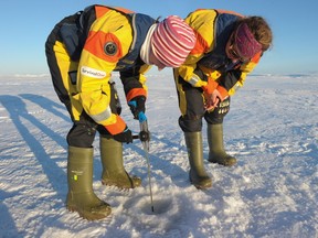 Ice specialists, from the University of Manitoba, drill an ice core, off the coasts of Devon Islands, in the Canadian High Arctic in September.