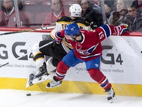 Boston Bruins' Zach Trotman (62) is checked into the boards by Montreal Canadiens' David Desharnais (51) during second period NHL hockey action, in Montreal, on Saturday, Nov. 7, 2015.