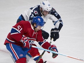 Montreal Canadiens' David Desharnais (51) and Winnipeg Jets' Tyler Myers battle for the puck during second period NHL action Sunday.