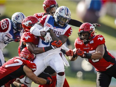 Montreal Alouettes' Dominique Ellis, centre, is tackled by Calgary Stampeders during first half CFL football action in Calgary on Saturday, August 1, 2015.