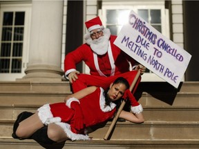 Activists dress up as Santa Claus holds a banner as he takes part in a global climate march at City Hall on Nov. 29, 2015 in New York City. The protest is part of an international weekend of action that is being mobilized to support climate activists in Paris whose massive march has been prevented by French authorities due to the recent attacks .Around 570,000 people have already marched in 2,300 events in 175 countries around the world.