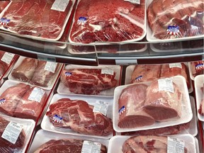 FILE - In this Nov. 2, 2013 file photo, various cuts of beef and pork are displayed for sale in the meat department at a discount market in Arlington, Va. The U.S. is running out of options to keep package labels on fresh cuts of meat that identify where animals were born, raised and slaughtered. The World Trade Organization has ruled that those labels discriminate against Canada and Mexico.