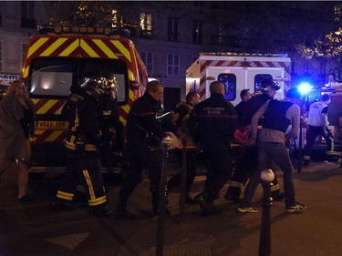 Rescuers workers evacuate victims near the Bataclan concert hall in central Paris, on November 13, 2015. A number of people were killed and others injured in a series of gun attacks across Paris, as well as explosions outside the national stadium where France was hosting Germany.