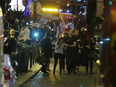 French security moves people in the area of Rue Bichat in the 10th arrondissement of the French capital Paris following a string of attacks on November 13, 2015. At least 18 people were killed as multiple shootings and explosions hit Paris, police said. Police also said there was an ongoing hostage crisis in the Bataclan a concert hall in the French capital.