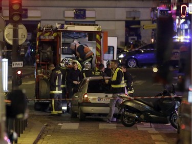Ambulance workers are seen at the scene in the 10th arrondissement of the French capital Paris, following a string of attacks, on November 13, 2015. At least 18 people were killed as multiple shootings and explosions hit Paris, police said. Police also said there was an ongoing hostage crisis in the Bataclan a concert hall in the French capital.