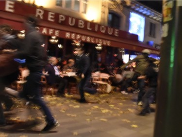 People run after hearing what is believed to be explosions or gunshots near Place de la Republique square in Paris on Nov. 13, 2015.