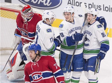 Vancouver Canucks centre Jared McCann (91) celebrates with teammates Vancouver Canucks right wing Jake Virtanen (18) and Vancouver Canucks right wing Radim Vrbata (17) after scoring the second goal against Montreal Canadiens goalie Mike Condon (39), during first period NHL action Monday, Nov. 16, 2015 in Montreal.