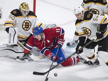Boston Bruins' defender Adam McQuaid (54) sends the puck away from Montreal Canadiens' Brendan Gallagher (11) in front of goalie Jonas Gustavsson (50) during first period NHL hockey action, in Montreal, on Saturday, Nov. 7, 2015.