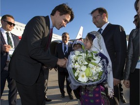 Prime Minister Justin Trudeau is presented with flowers as he arrives in Antalya, Turkey, on Saturday, Nov. 14, 2015, to take part in the G20 Summit.