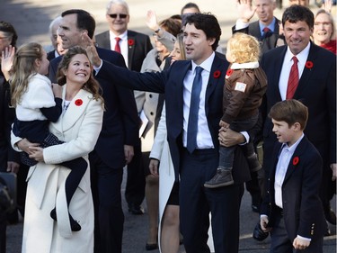 Prime Minister-designate Justin Trudeau holds son Hadrien while his wife Sophie Gregoire-Trudeau holds daughter Ella-Grace and their oldest son Xavier walks alongside as they arrive at Rideau Hall with Trudeau's future cabinet to take part in a swearing-in ceremony in Ottawa on Tuesday, November 4, 2015.