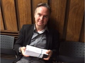 Kristian Gravenor sits outside municipal court in Pointe-Claire with a stack of tickets he is contesting for graffiti on his building in Ste-Anne-de-Bellevue. Monday, Nov. 2, 2015. (Photo by Cheryl Cornacchia, Montreal Gazette)