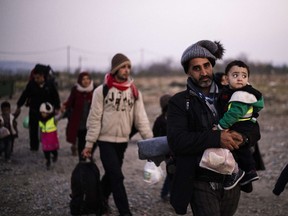 Migrants and refugees walk after crossing the Greek-Macedonian border near Gevgelija on Nov. 17, 2015. This week we asked you whether the Canadian government's target of welcoming 25,000 refugees to Canada by Jan. 1 was realistic. The results of that poll are in.
