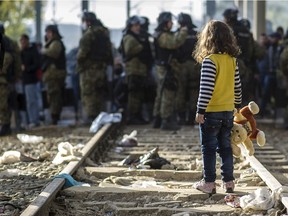 Macedonian police officers block migrants and refugees at the Greek Macedonia border, on the main migrant route to northern Europe.