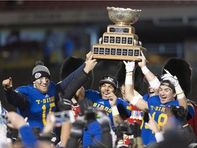 UBC Thunderbirds Terrell Davis, centre, raises the Vanier Cup trophy with quarterback Michael O'Connor, left, and Stavros Katsantonis, right, after winning against the Montreal Carabins, Saturday, Nov. 28, 2015 in Quebec City.
