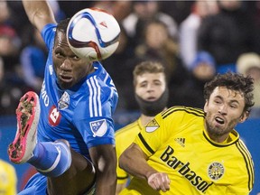 Montreal Impact's Didier Drogba, left, challenges Columbus Crew SC's Michael Parkhurst during first half first leg MLS playoff soccer action in Montreal, Sunday, Nov. 1, 2015.