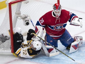 Boston Bruins' Frank Vatrano (72) slides into the net as Montreal Canadiens' goalie Mike Condon defends the crease during second period NHL hockey action, in Montreal, on Saturday, Nov. 7, 2015.
