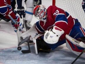 Montreal Canadiens goalie Mike Condon reaches down to smother the puck during third-period NHL action against the Winnipeg Jets, Sunday Nov. 1, 2015 in Montreal.