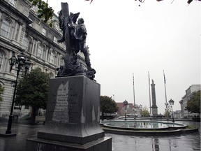 Statue of French naval commander Jean Vauquelin (foreground) sits in Place Vauquelin across the street from the Nelson's column in Place Jacques Cartier.