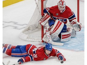 Canadiens defenceman Nathan Beaulieu attempts to block a shot by the New York Islanders as goalie Dustin Tokarski looks on during game at the Bell Centre in Montreal on Jan. 17, 2015.