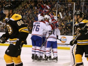 Canadiens players including P.K. Subban (76) and Alexander Semin (13) congratulate David Desharnais (51) after he scored a goal as Boston Bruins players Kevan Miller (86) and Joe Morrow (45) skate away during the first period of an NHL hockey game in Boston, Saturday, Oct. 10, 2015.