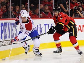 Kris Russell of the Calgary Flames checks David Desharnais of the Montreal Canadiens during an NHL game in Calgary on Oct. 30. The Habs' No. 3 line, centred by Desharnais, led the way offensively during the weekend.
